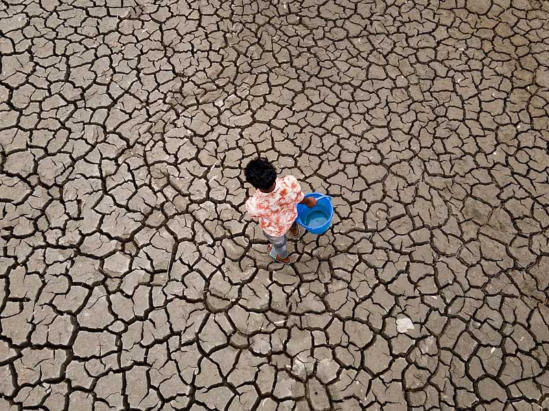 A young man braves the drought, trekking to a reservoir to collect water in the arid landscape of Satkhira, Bangladesh;
©Muhammad Amdad Hossain